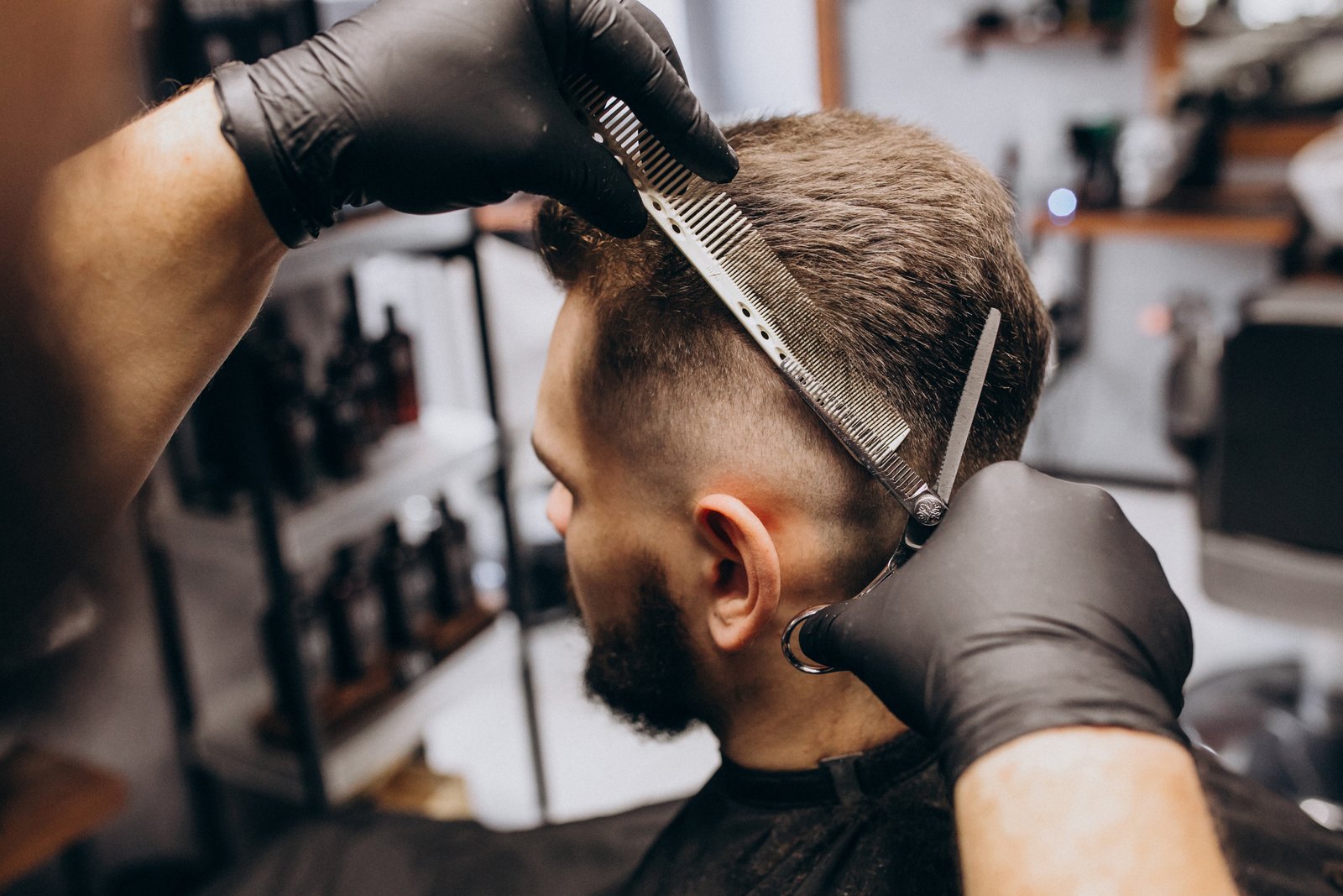 Barbeiro finalizando corte de cabelo masculino com tesoura e pente em Joinville